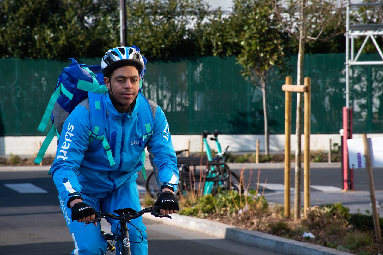 courier wearing blue uniform riding a bike