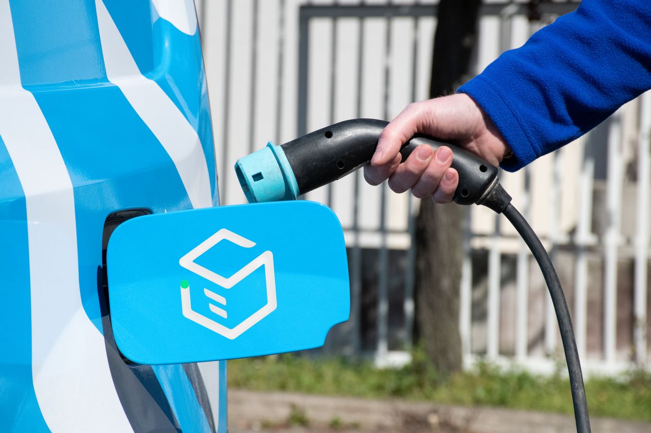 Human man feeding an electric vehicle